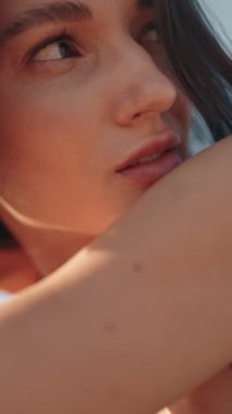 Çekici bir genç kadının yavaş çekim güzel portresi. Kahverengi gözleri ve rüzgarda uçuşan kahverengi saçları var..