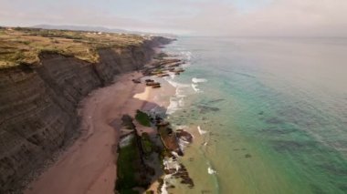 Magoito Sahili, Portekiz: Mavi su, kumlu sahil, yeşil bitki örtüsü ve kayalıklar. Yüzmek, güneşlenmek ve sörf yapmak için ideal..