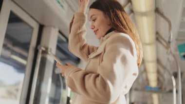 Samimi bir anda, bir tramvayın içinde sabırla beklerken genç bir kadın telefonuyla meşgul oluyor..