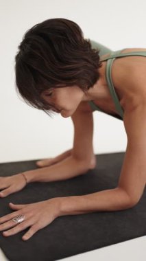 Yoga pozu veren sakin ve odaklanmış dişi yogi. Kapalı alan ayarları asana uygulamasının sükunetini arttırıyor..