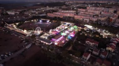 Karnaval gezileri, parlak ışıklar ve lunaparkta eğlence. Yerel bir panayırın harika hava manzarası.
