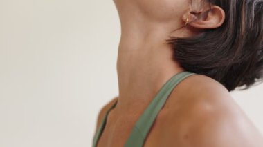 Bir kadının boyun kaslarını gösteren yakın plan bir çekim. Güneş selamı yoga pozunda esnerken, insan formunun güzelliğini gösteriyor..