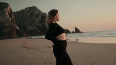 Gün batımında sakin bir plajda zarif bir şekilde dans eden bir kadın dinginliği ve güzelliği yakalar. Sahne, okyanus kıyısındaki huzur ve özgürlük duygusunu çağrıştırıyor..