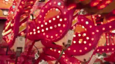 Lunapark atlıkarıncasında yanıp sönen ışıkların yakın görüntüsü. Karnavallar, festivaller, devlet fuarları, yaz eğlencesi, eğlence ve çocukluk projeleri için harika.