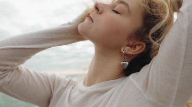 Anlamlı bir dansçı deniz kenarında modern bir poz verir. Huzurlu bir günbatımının arka planıyla özgürlüğü ve zarafeti çağrıştırır..