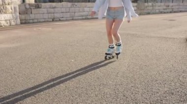 Genç bir kadın güneşli bir yaz gününde dışarıda paten kayıyor, rahatlık ve özgürlüğün tadını çıkarıyor. Tanınmaz halde..