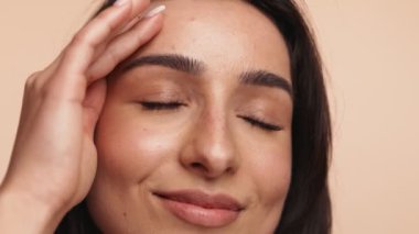 Stüdyonun arka planına hafifçe dokunan bir elle sağlıklı ten kavramı..