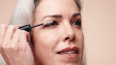 Son sınıf bir kadının kirpiklerinde rimel sürerken doğal güzellik ve zarif yaşlanma kavramını vurgulaması..