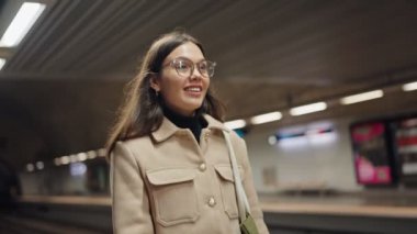 Çağdaş giyimli bir insan hareketli bir metro istasyonunda yürüyor, şehir hayatının ve günlük yolculuğun özünü yakalıyor..