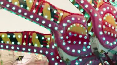 Renkli bir atlı karınca lunaparkta ya da gece yarısı lunaparkta dönüyor. Yeşil ve kırmızı ışıklar yolu aydınlatıyor..