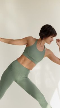Huzurlu bir ortamda yan tahtayla poz veren odaklanmış bir birey, yoga asanasında denge ve gücü yansıtıyor..