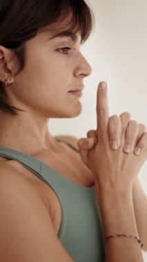 Sakin bir kadının yoga kıyafetleri içinde durgun bir asana duruşu içinde, huzuru ve farkındalığı somutlaştırıyor..