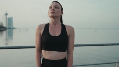 Formda bir bayan koşucu, yoğun bir gün batımı egzersizinden sonra sakin sularda dinlenmeyi hak ediyor..