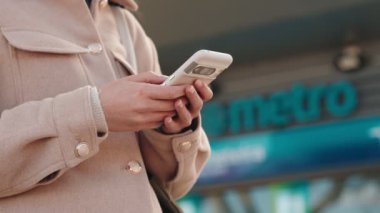 Biletleri internet üzerinden almak için akıllı telefon kullanan el kameraları bir metro gişesinin yanında duruyor..