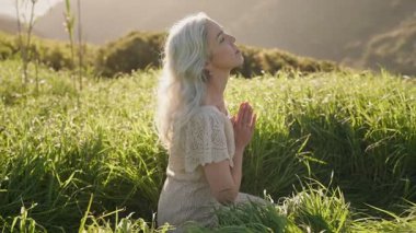 Gün batımının sıcacık parıltısında uzun otların arasında meditasyon yapan bir kadın, huzur, sükunet ve farkındalığı kucaklıyor..