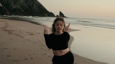 Güzel bir gün batımında, sakin bir plajda dans ederek güzellik ve özgürlüğü ifade eden bir kadın, dinginlik ve hareketin özünü yakalar..