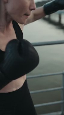 Açık havada boks antrenmanı yapan bir kadının yakın plan çekimine odaklan..