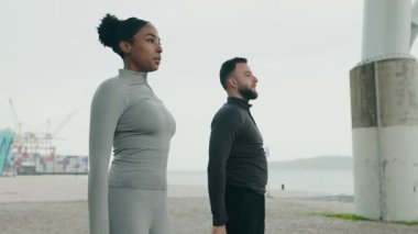 Siyahi bir kadın ve Kafkasyalı bir erkek birlikte spor yapıyorlar, fitness ve çeşitliliği destekliyorlar..