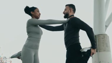 Aktif giyimli çeşitli erkek ve kadın çiftler birlikte esneyerek, açık hava ortamında fitness ve arkadaşlığı teşvik ediyorlar..