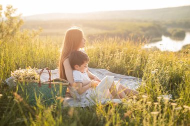 Güneşli, doğal bir ortamda güzel vakit geçiren bir anne ve çocuğun sakin bir sahnesi..