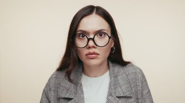 Kafası karışmış, gözlüklü, somurtkan ve geçmişi olan genç bir kadının yakın çekimi..