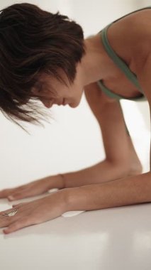 Yoga pozu veren sakin ve odaklanmış dişi yogi. Kapalı alan ayarları asana uygulamasının sükunetini arttırıyor..