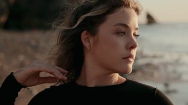 Genç bir kadın, gün batımında kumsalda dans ederken özgürlük ve sükunetin özünü yakalarken huzur ve duygusunu ifade eder..