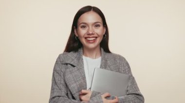 Şık giyinmiş, kendine güvenen ve akademik zorluklara hazır bir öğrenci dizüstü bilgisayarını tutuyor..