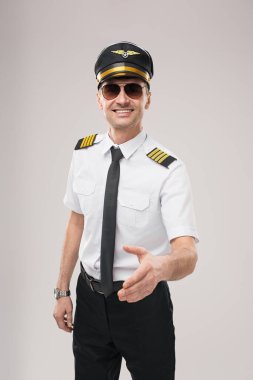 Üniformalı profesyonel havayolu pilotu dostça tokalaşıyor. Havacılık, konukseverlik, ulaşım ve müşteri hizmetleri ile ilgili kavramlar için ideal.