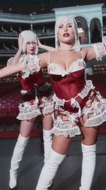 Burlesque giymiş iki güzel ve göz kamaştırıcı bayan dansçı, şov kızı kıyafetleri boş bir sahnede poz veriyor. Seksi iç çamaşırları ve inci başlıklar giyiyorlar..