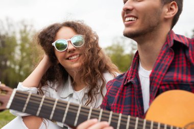 İki arkadaş güneşli bir günde dışarıda müzik ve kahkahalarla vakit geçiriyorlar..