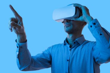 Bir adam, yenilikçi uygulamalar için sanal gerçeklik teknolojisini dinamik bir ortamda, simüle edilmiş dijital arayüzlerle sorunsuz bir şekilde etkileşimde bulunarak keşfediyor..