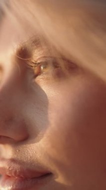 Sarışın, mavi gözlü, gün ışığına bakan bir kadının yakın çekimi. Güzellik, sükunet ve umut teması için ideal..