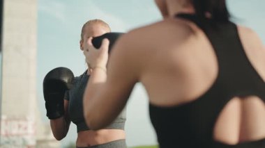 Boks eldivenli kararlı bir kadın spor salonunda antrenman yapıyor ve fitness hedeflerine odaklanıyor..