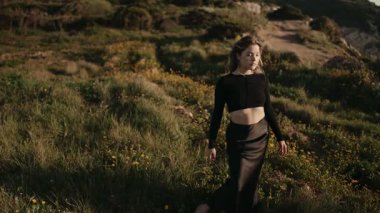 Rüzgarlı bir günde, güzel bir kadın bir tarlada hareketsiz duruyor, doğanın ortasında huzur ve tefekkür tasvir ediyor..