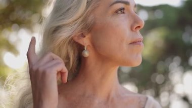 Düşünceli olgun bir kadın dışarıda eğleniyor. Bu video barış, huzur ve yaşlanmanın güzelliğini çağrıştırıyor..