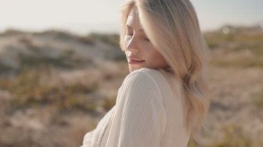 Baştan çıkarıcı genç bir kadın kumsaldaki kameraya bakarak ellerini saçlarının arasında gezdiriyor. O, beyaz bir elbise giyiyor. Videonun sıcak, baştan çıkarıcı ve davetkar bir tonu var..