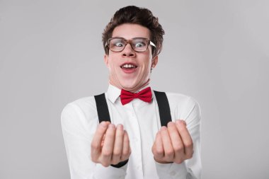 Heyecanlı ve neşeli bir ifade sergileyen, şık gözlükler takan, kırmızı papyon takan ve pantolon askısı takan hevesli genç bir adam. Duyguları, mizahı, inek kültürünü veya yaratıcılıkla ilgili konuları göstermek için mükemmel..