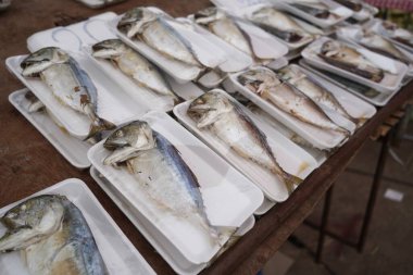 Bir market tezgahında taze uskumrular ve sardalya ve küçük uskumrular da dahil olmak üzere yerel balıklar satışta, geleneksel deniz ürünleri ticareti, canlı pazar yerleri ve Tayland kıyılarındaki günlük yaşam sunuluyor..