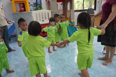 Tayland Çocuk Günü 'nde bir grup neşeli, sevimli çocuk oyun oynuyor ve eğleniyor. Gülümseyen mutlu çocukların portresi. Arkadaşlık konsepti, 13 Ocak 2024, Buriram Tayland.