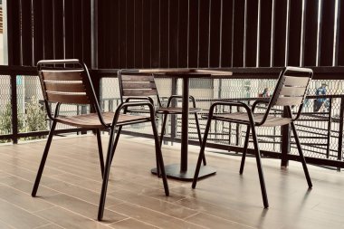 Modern yükseltilmiş sandalye barı, sandalyeler gevşek masa tropikal ev ve kafeterya tarzı için ahşap zemin.