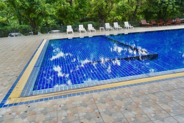 Tatil köyü, boş dikdörtgen mavi yüzme havuzu güneş yatakları, şemsiyeler ve büyük şişme sarı ananas yüzen tüp. Emlak kiralamak ya da yaz tatilini lüks tatil beldelerinde geçirmek..