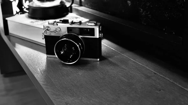 Retro vintage film camera on woodent table , monotone color background.