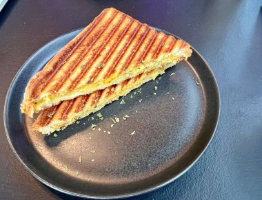 Taze pişmiş jambonlu ve peynirli sandviçte erimiş peynir, tuzlu jambon ve altın ekmek kahvaltıda, öğle yemeğinde ya da aperatifte sıcak, lezzetli ve tatmin edici bir yemek sunulur..