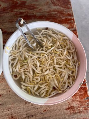 Taze fasulye filizleri temiz suya batırılmış taze dokularını, doğal tazeliklerini ve pişirme ve sağlıklı yemek hazırlıklarını vurguluyor..