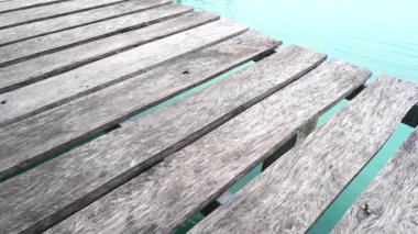 Su üzerindeki ahşap palet köprüsünün yemyeşil pirinç tarlasında 4K videosu. Kırsal yaşam tarzı, huzurlu kırsal atmosfer, doğal manzara ve Tayland tarım arazilerindeki basit yaşam. Seyahat, doğa ve kültürel temalar için mükemmel..