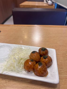 Takoyaki, ünlü Japon sokak yemeği, ağızda sulandıran ahtapot dolu bir aperatiftir. Dışarıdan çıtır çıtır ve içi yumuşaktır. Japon lezzetinden mükemmel bir ısırık alır..