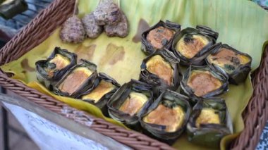 Tayland sokak yemekleri Kai Pam 'i muz yaprağında pişirmek, muz yaprağında ızgara yumurta Kömür ızgarasında Yaprak Bardağı.