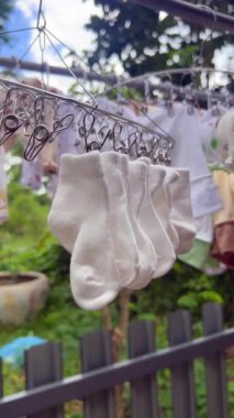 Bebek kıyafetleri ve vücut kıyafetleri Sunlight Fresh çamaşırhanesinde kurutuluyor, Bebek Moda Stoku Videoları, 4K kalite..