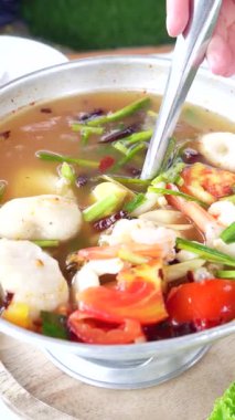 Tay Tom Yum deniz ürünleri güveç, karides, kalamar, midye ve bitkilerle baharatlı ve ekşi çorba videosu. Geleneksel Tayland mutfağı sıcak ve buharlı servis edilir, Asya yemekleri için mükemmeldir..